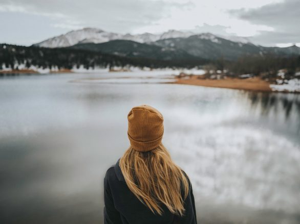 Frau an einem See steht für die Work-Life-Balance